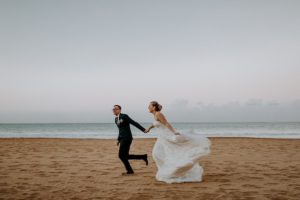 bride and groom running on a beach in Puerto Rico